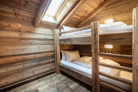 Chambre avec lit supersposé, la chambre est du sol au plafond fini avec un revetement bois