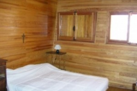 Chambre en bois avec lit double, deux fenêtres