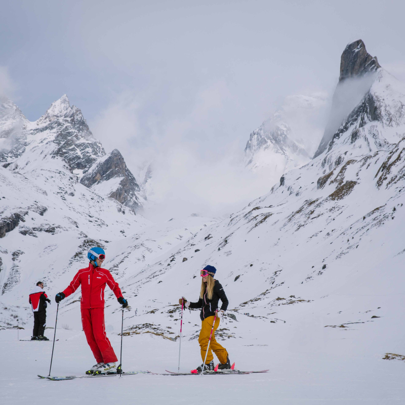 Skier in a private lesson at the ski area with a view of Aguille de la Vanoise Spire