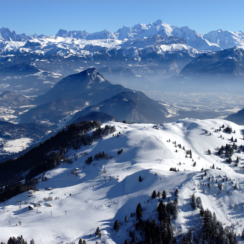 Vue sur le domaine skiable du Massif des Brasses et la chaine du Mont Blanc au loin