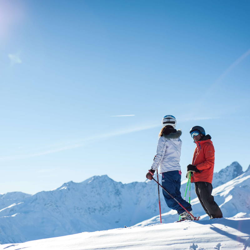 Un couple de skieurs sur le Crey du Quart, admirant la vue sur les Aiguilles d'Arves depuis Valloire