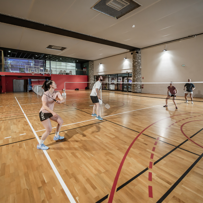 Sportifs en train de jouer au badminton dans la salle multi-sports du Centre Aquasportif de Val d'Isère