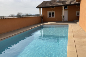 Le gîte propose une terrasse couverte avec vue sur la piscine.