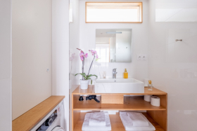 Salle d'eau lumineuse avec douche spacieuse, sèche-cheveux, lave-linge et serviettes