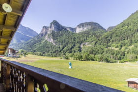 Vue depuis le balcon : montagnes et piste de ski débutants