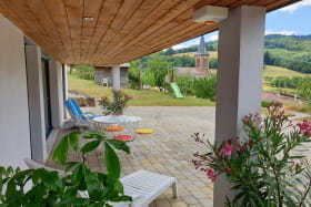'Gîte de la Rue de la Tour' à Valsonne (Rhône - Beaujolais Vert - région Lac des Sapins) : la terrasse abritée avec salon de jardin et bains de soleil