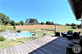 Grand gîte des Chambres de L'Ouest à Longessaigne (Rhône, Monts du Lyonnais) : grande terrasse en bois (60 m²) avec vue sur piscine.