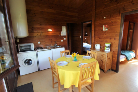 Chalet-Gîte du Plan d'eau d'Azole (Gîte N° 6) à Propières (Rhône - Haut Beaujolais): séjour, espaces repas et cuisine.